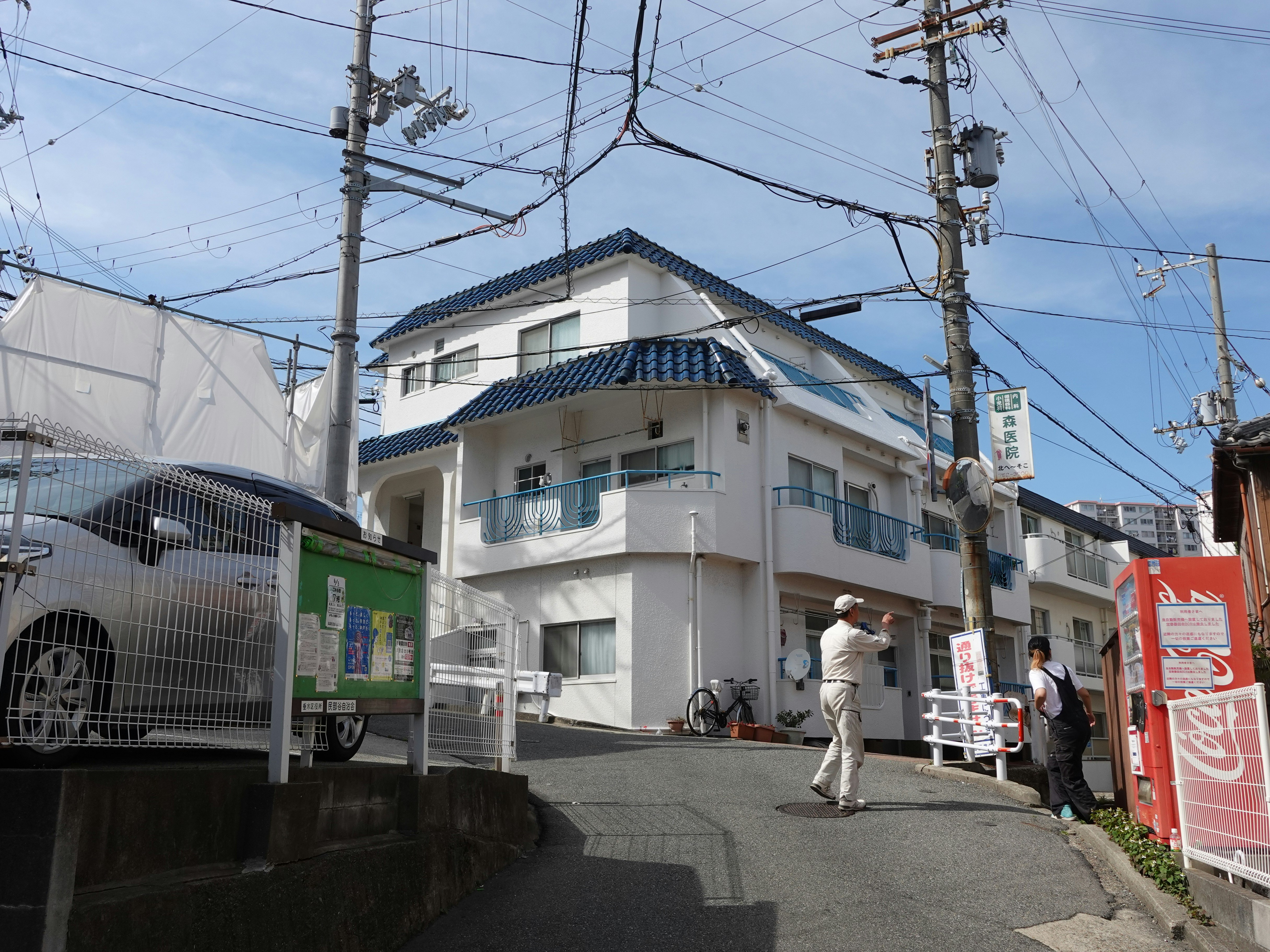 residential alleyway slope with utility poles and overhead wires