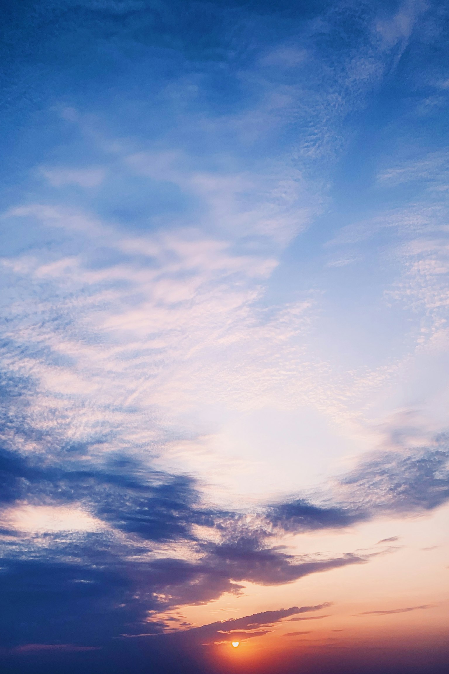 Schöner Sonnenuntergang mit Wolken in einem blauen Himmel