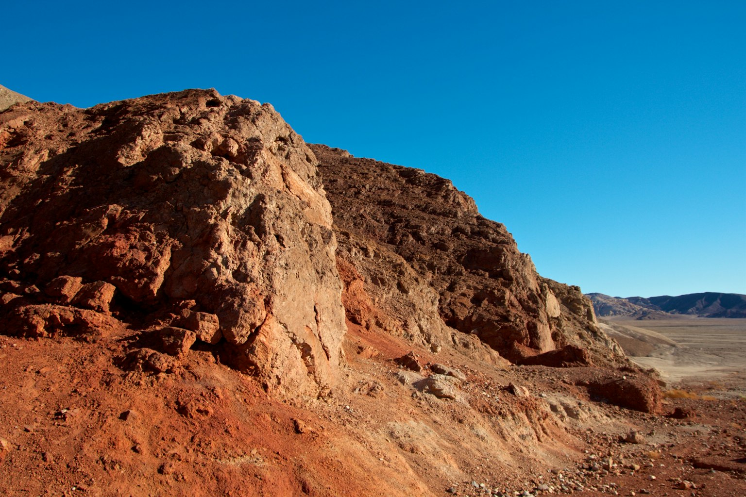 Paisaje de rocas marrón rojizo bajo un cielo azul vibrante