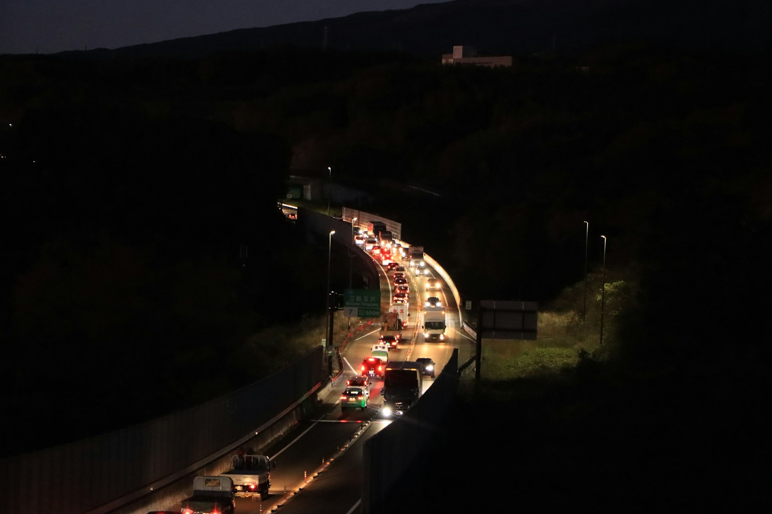 Eine kurvenreiche Straße bei Nacht mit fließendem Verkehr und Straßenlaternen