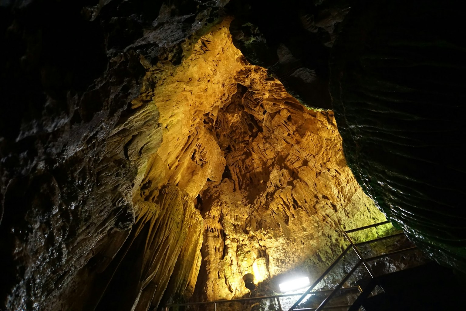 Illuminated cave ceiling showcasing intricate rock formations and colors