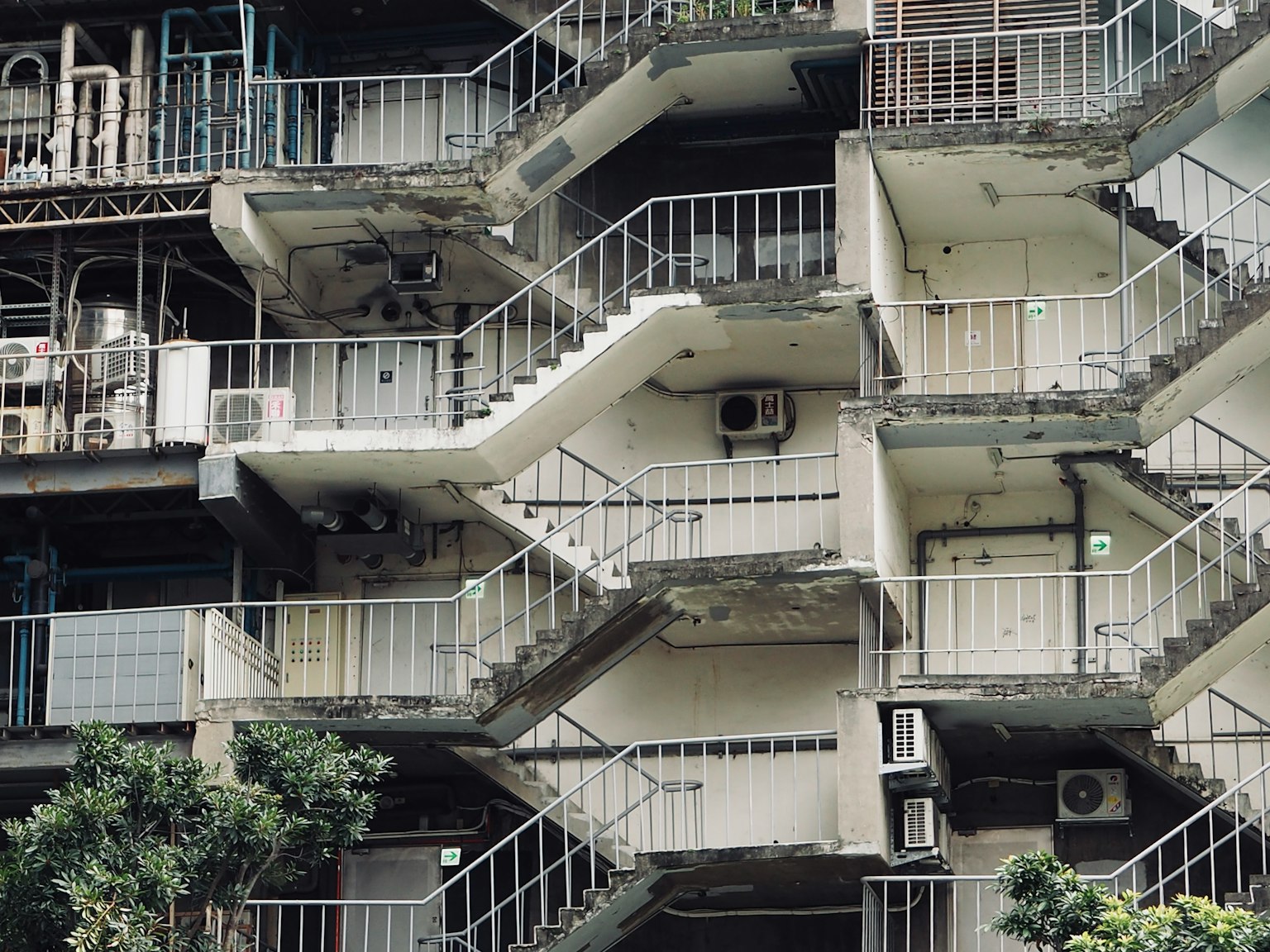Exterior of a building with distinctive staircases various staircases and air conditioning units visible