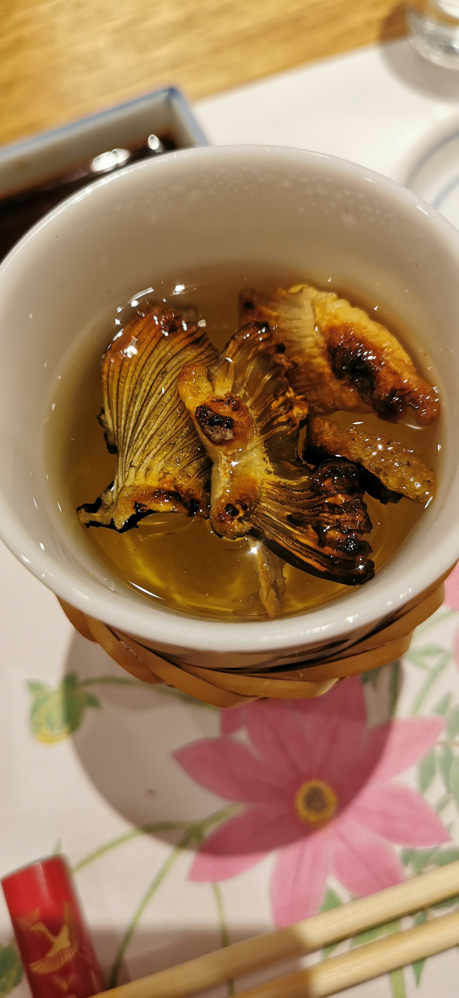 Una ciotola con pesce grigliato e erbe in brodo