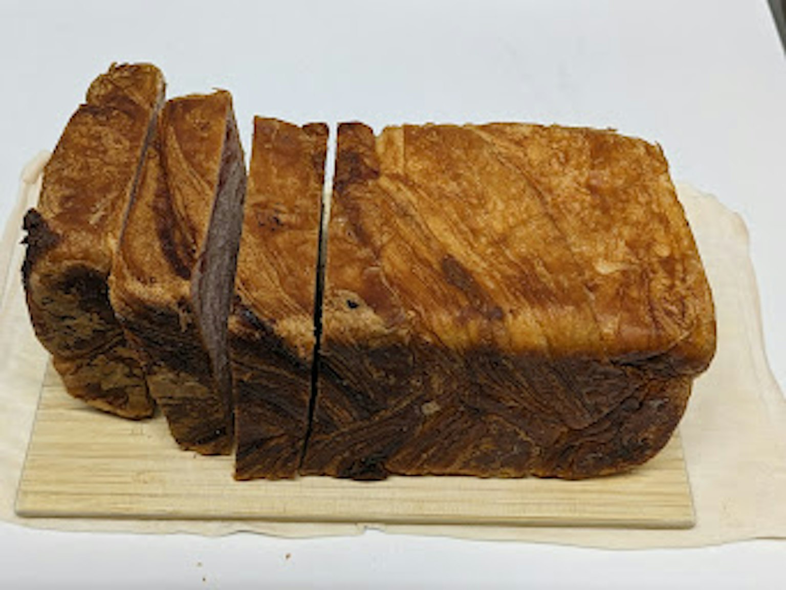 Freshly baked bread slices arranged on a wooden board