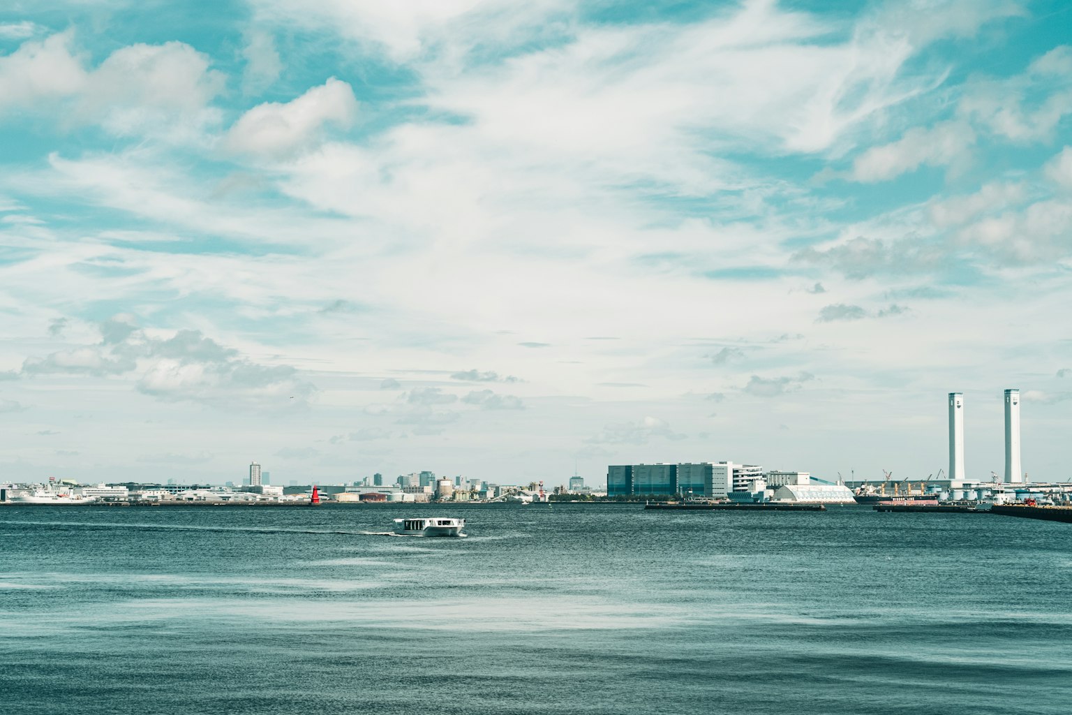 Vista escénica de un puerto con aguas azules y cielo nublado