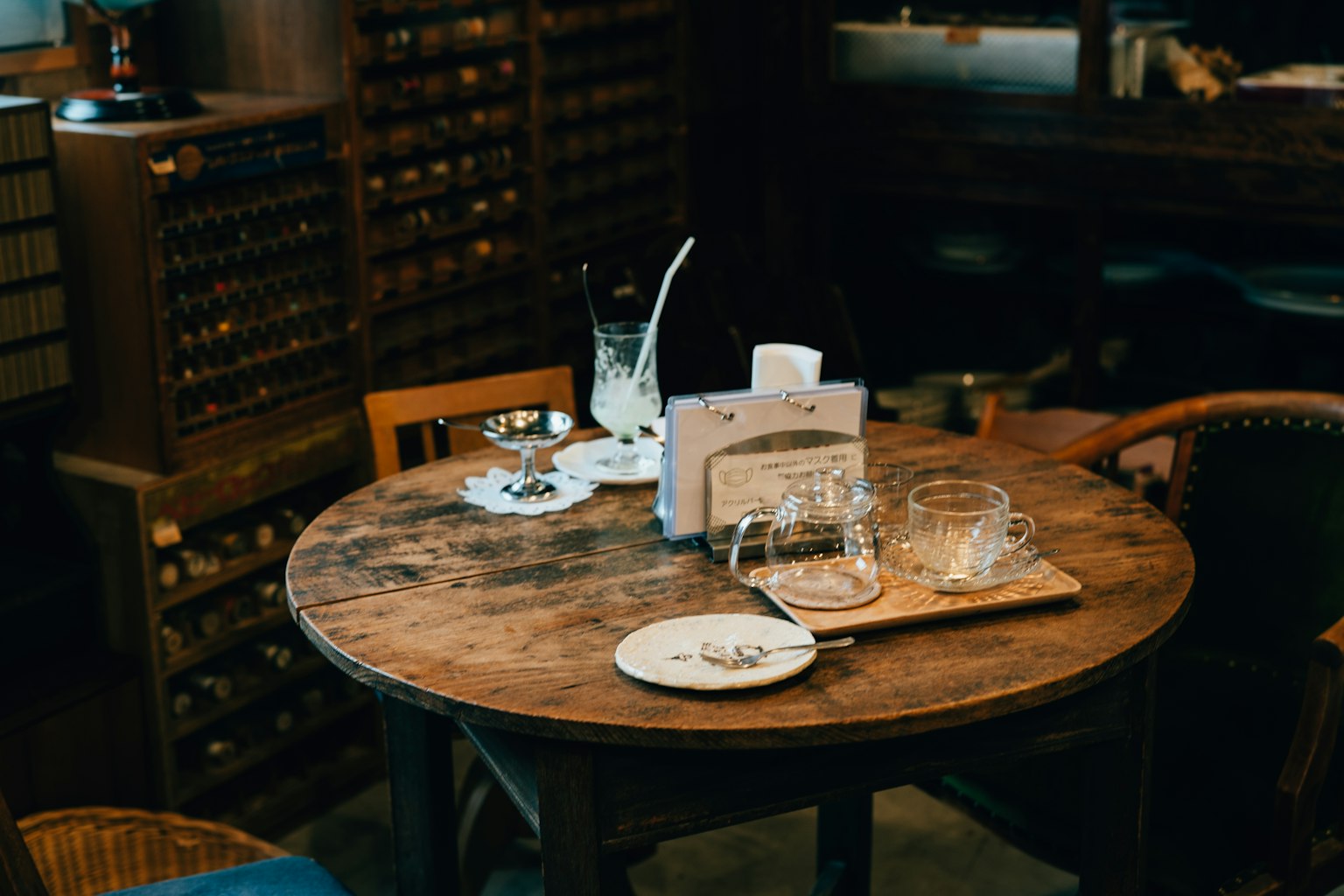 Mesa de madera con vasos y un plato en un café