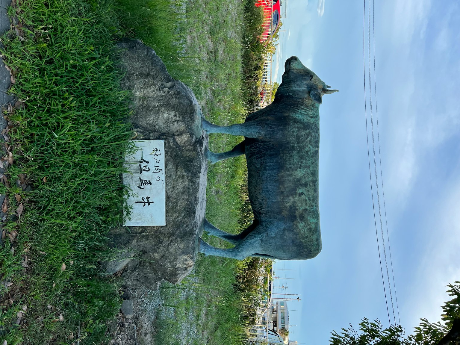 一隻牛雕塑站在草地上