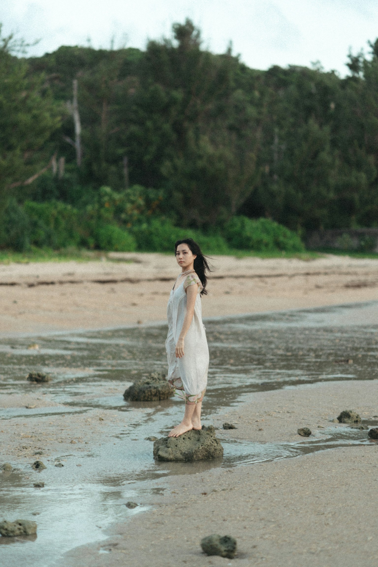在自然中站在海滩岩石上的女性