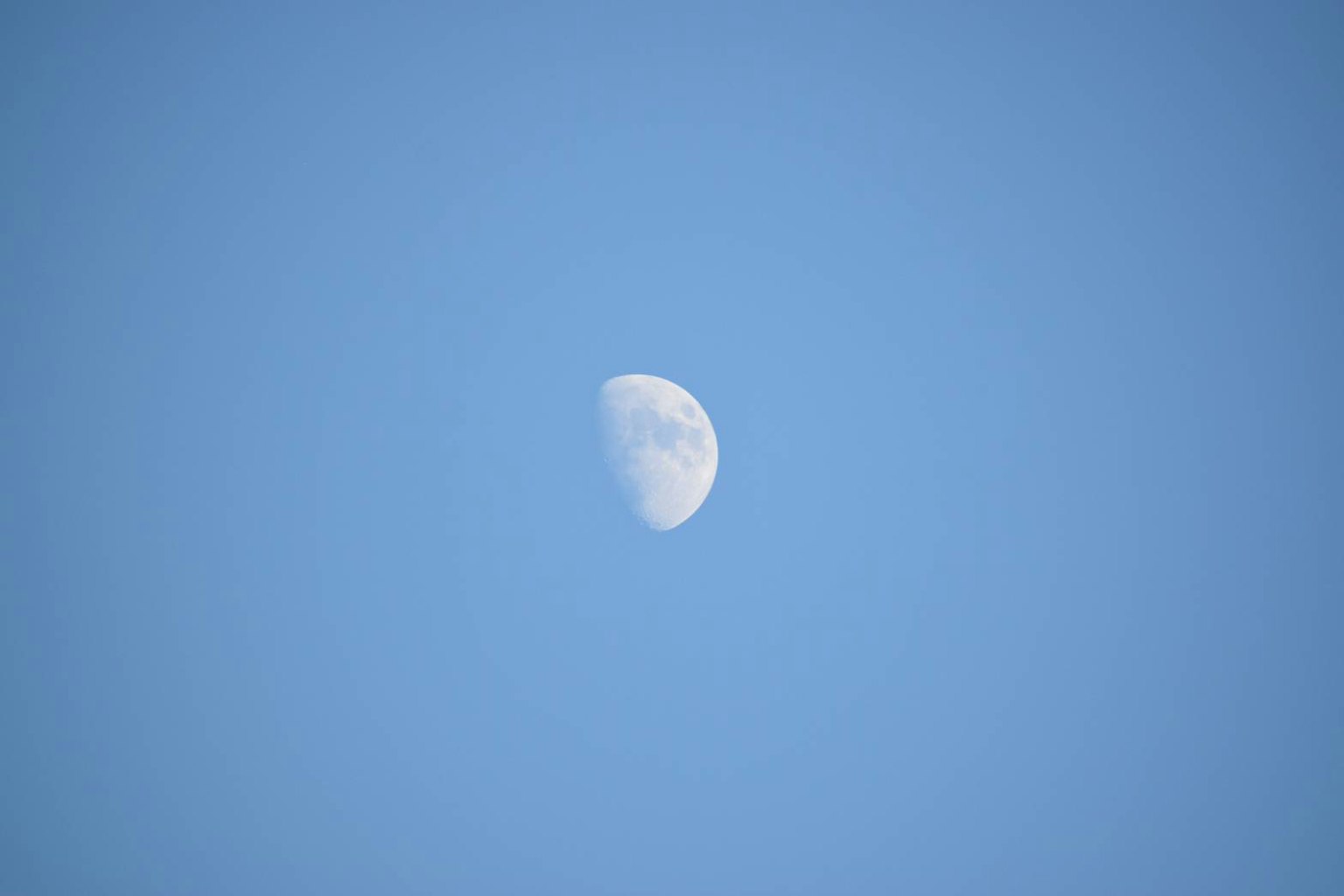 Hermosa vista de una luna creciente en el cielo azul