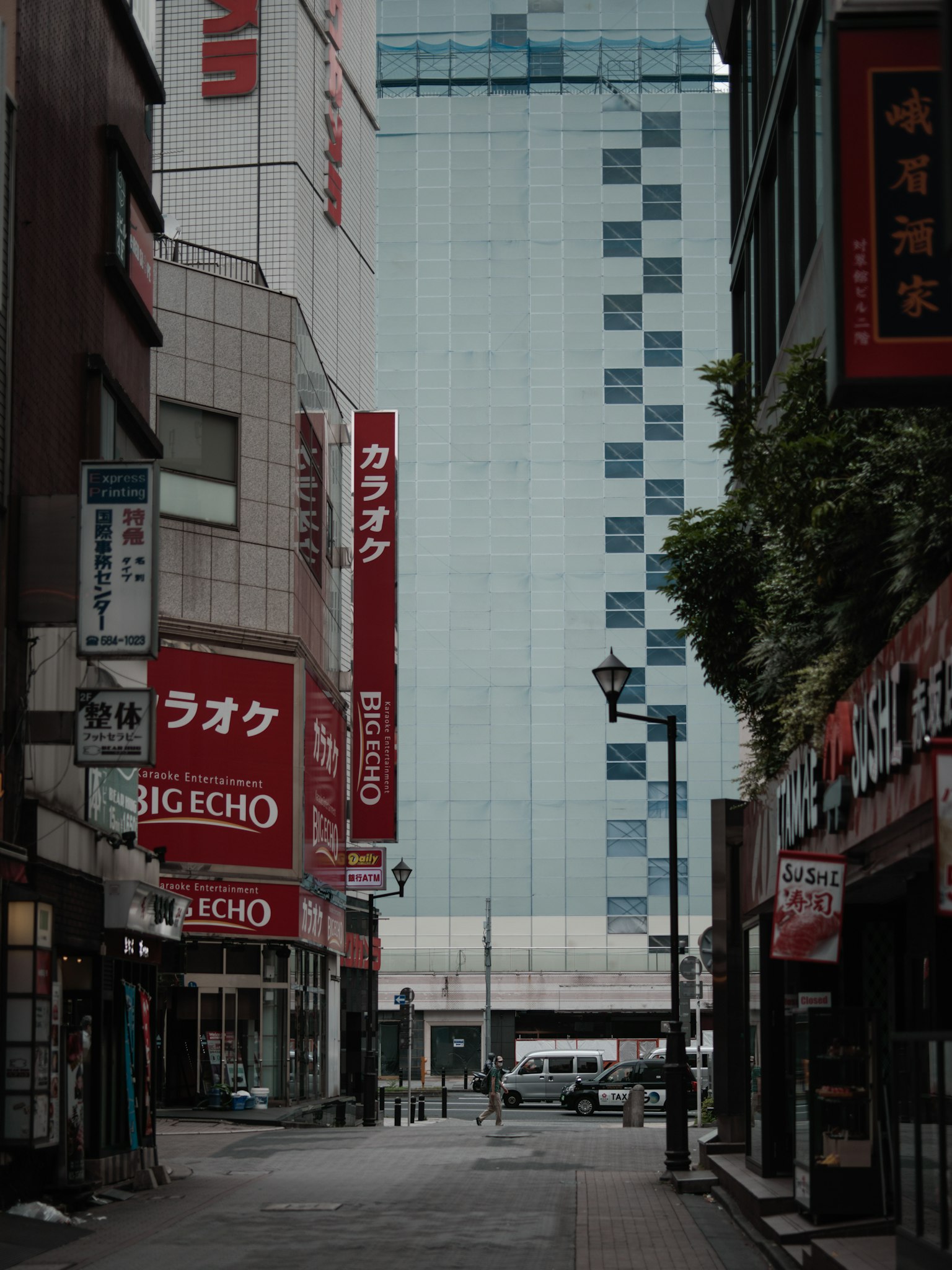 Calle estrecha con edificios y letreros en un entorno urbano