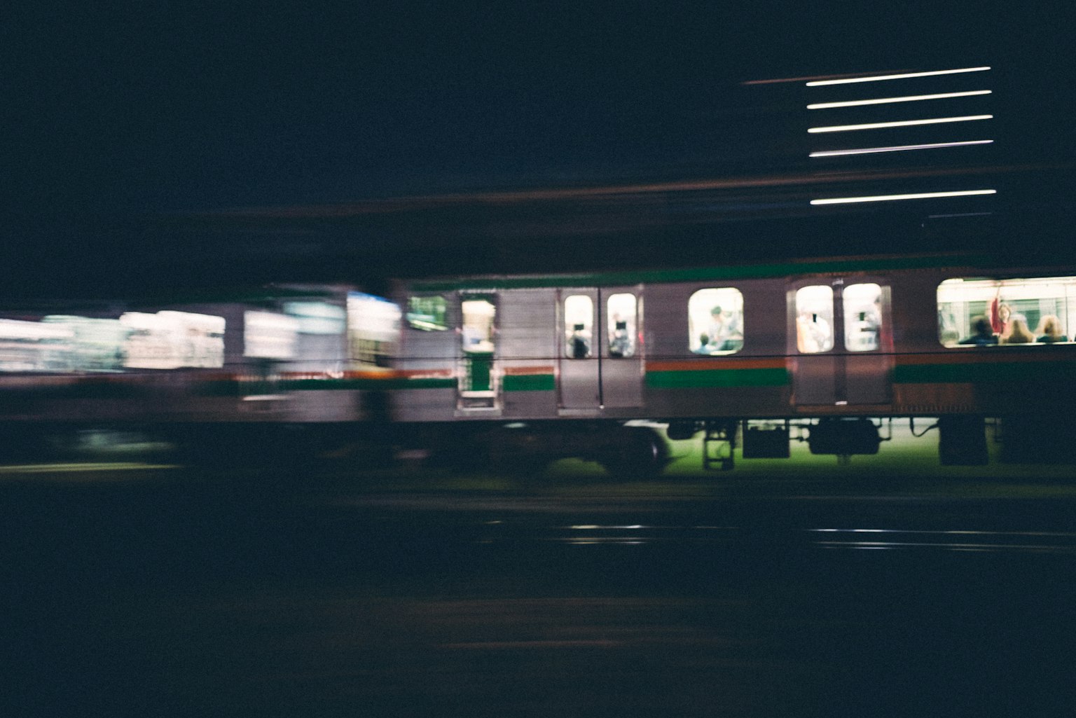 Image floue d'un train en mouvement la nuit avec des fenêtres éclairées