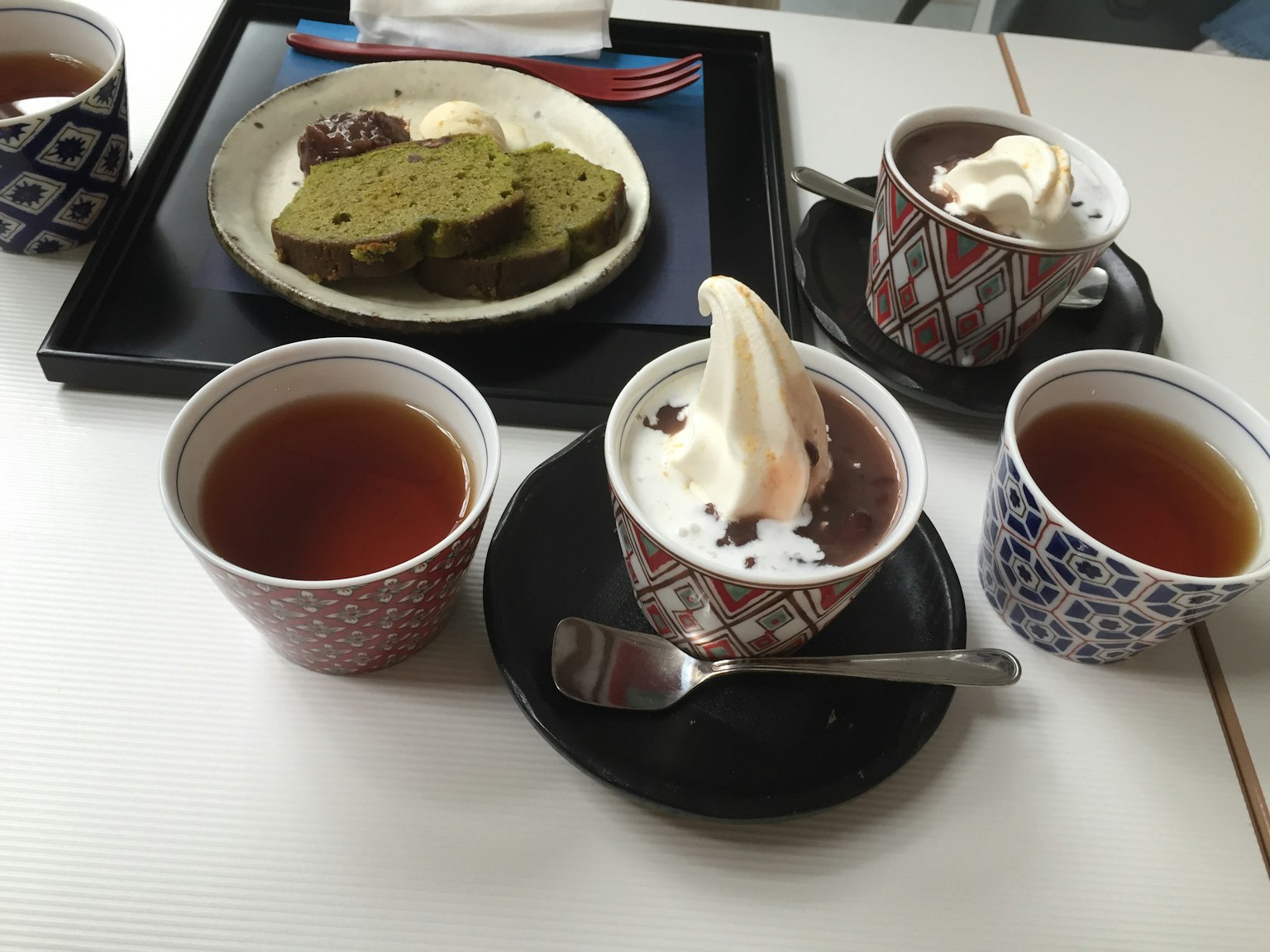 Pemandangan meja dengan kue teh hijau dan pencuci mulut dengan es krim