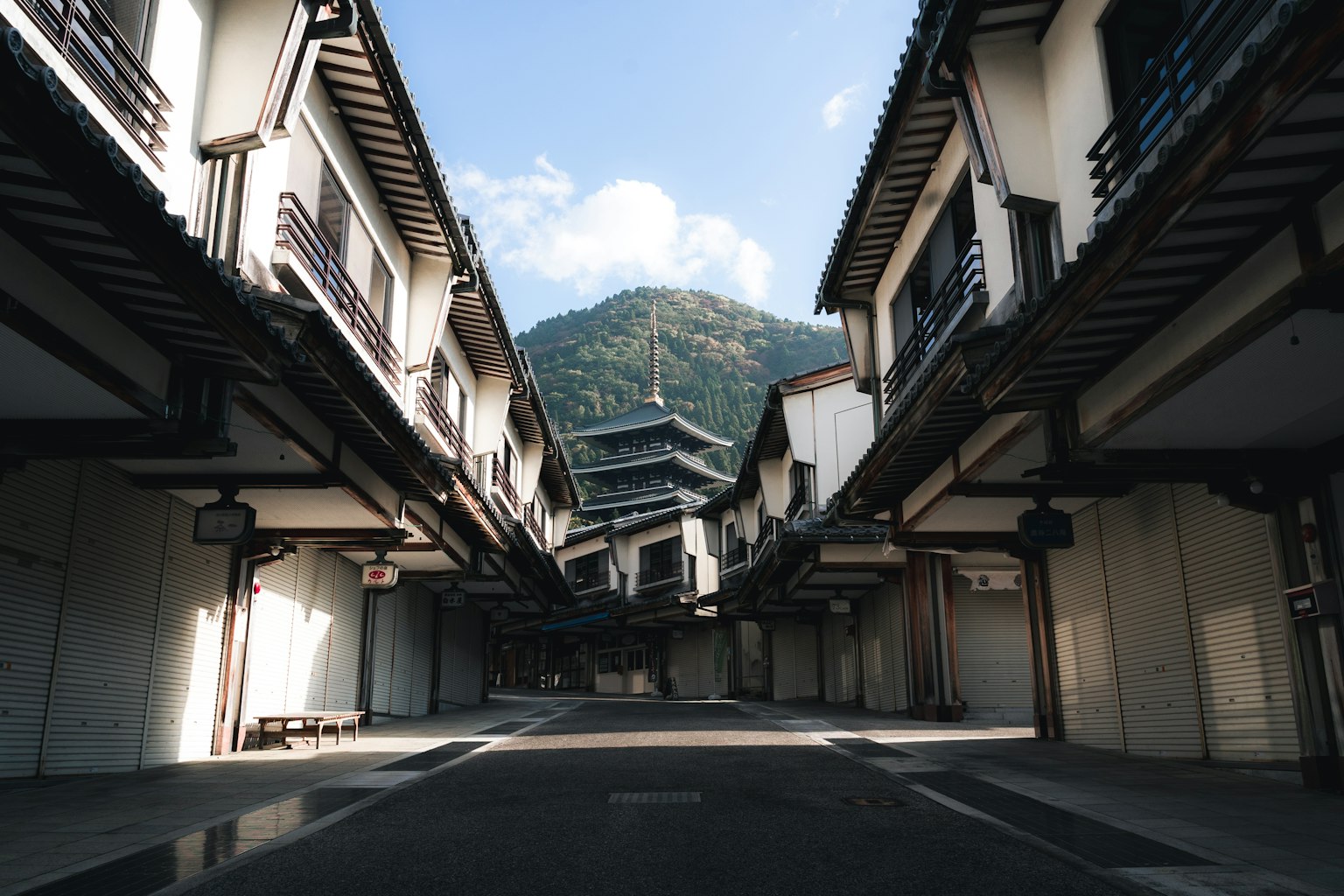 Quiet street lined with traditional buildings and a mountain backdrop