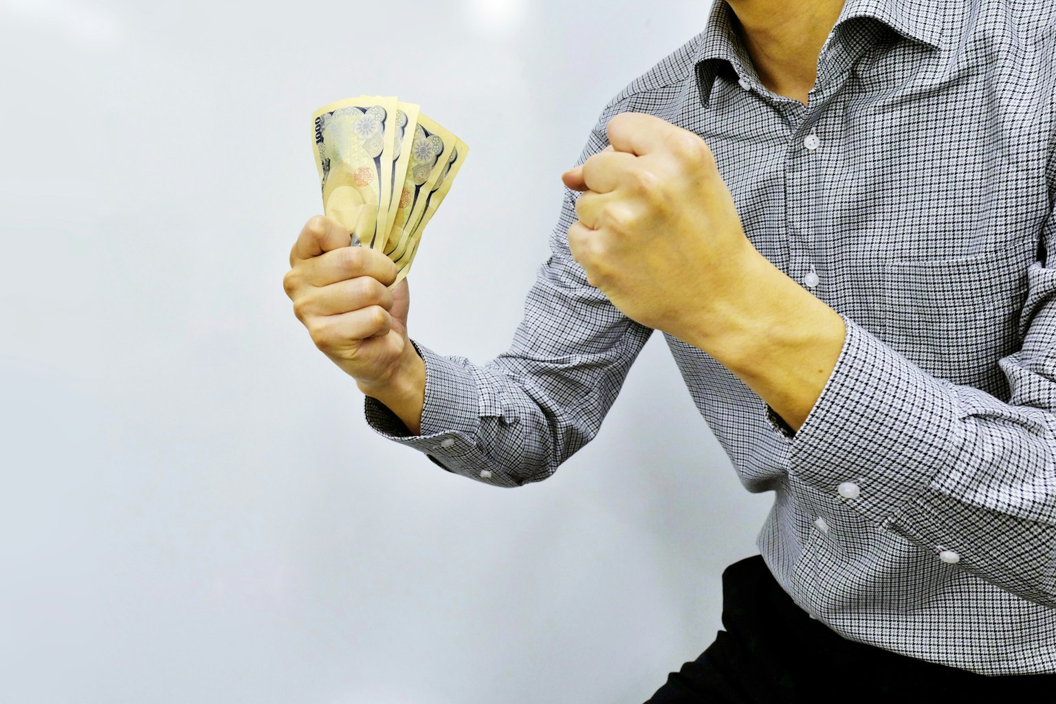Uomo che tiene un mazzo di banconote con un'espressione determinata