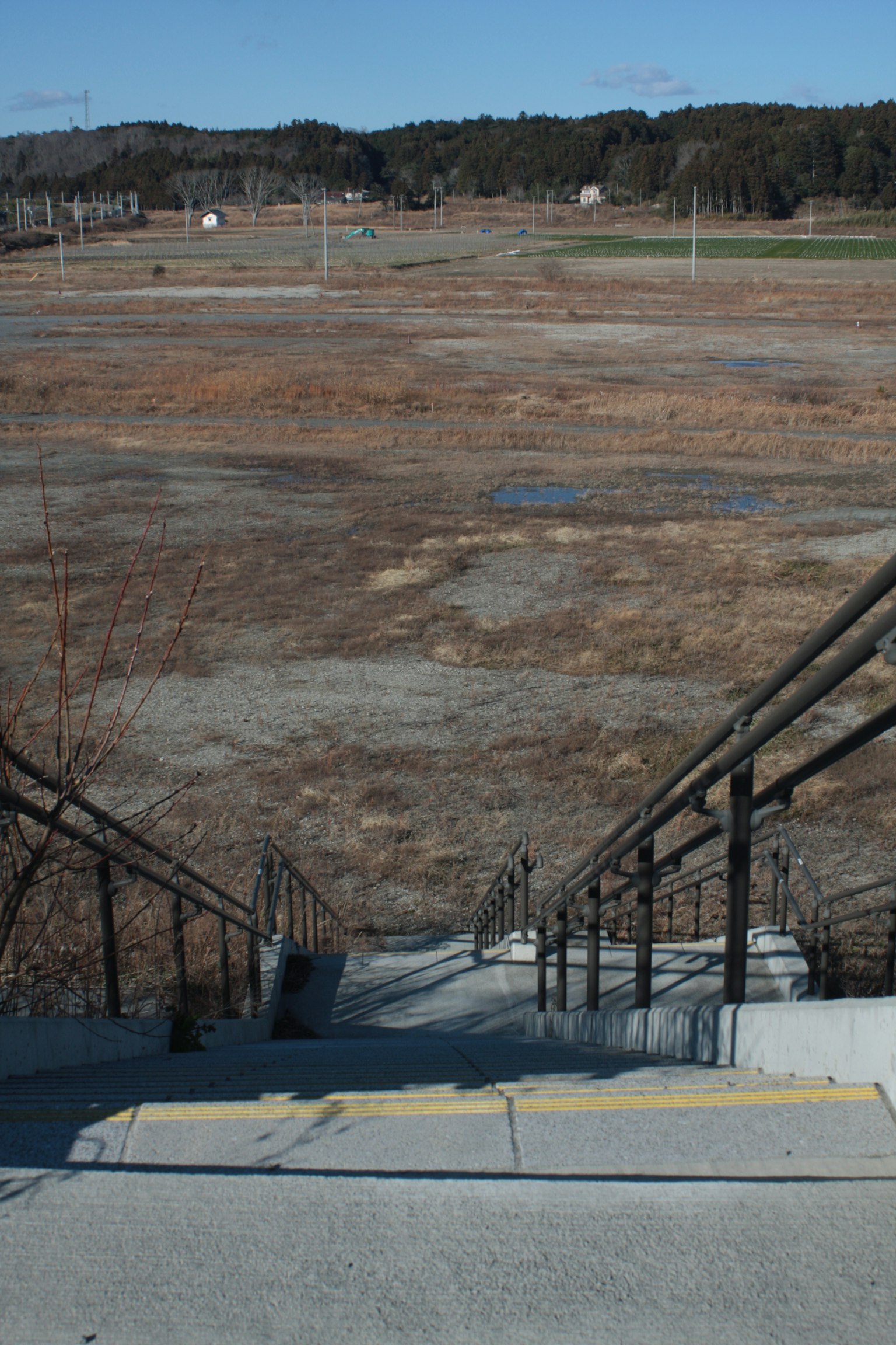 Stairs leading down to a dry landscape under a clear blue sky