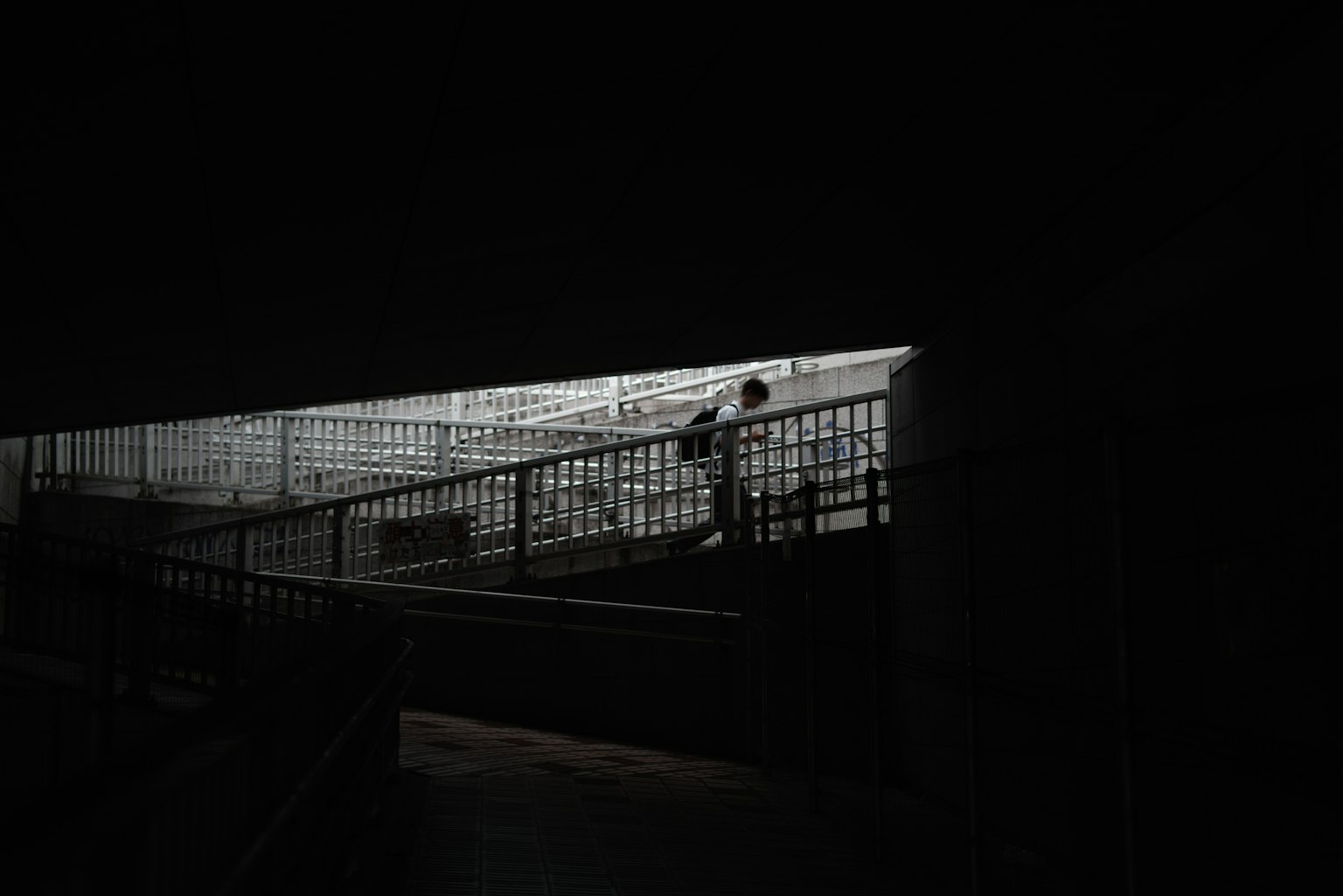 在黑暗空間中攀登明亮樓梯的人影