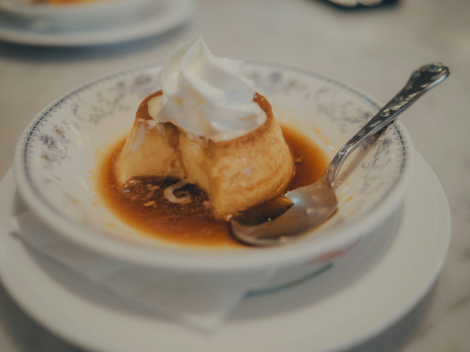 クリーミーなフランとホイップクリームがトッピングされたデザートの皿