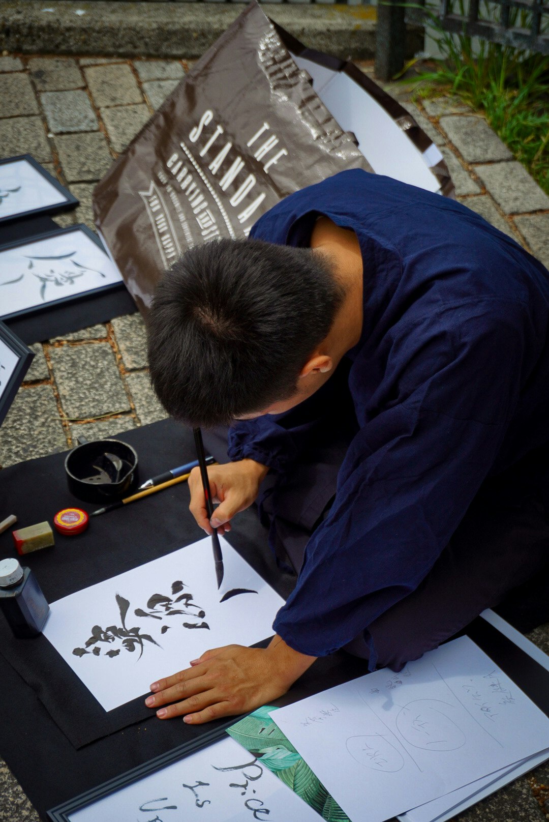 artista di calligrafia in strada al lavoro su un tavolo all’aperto
