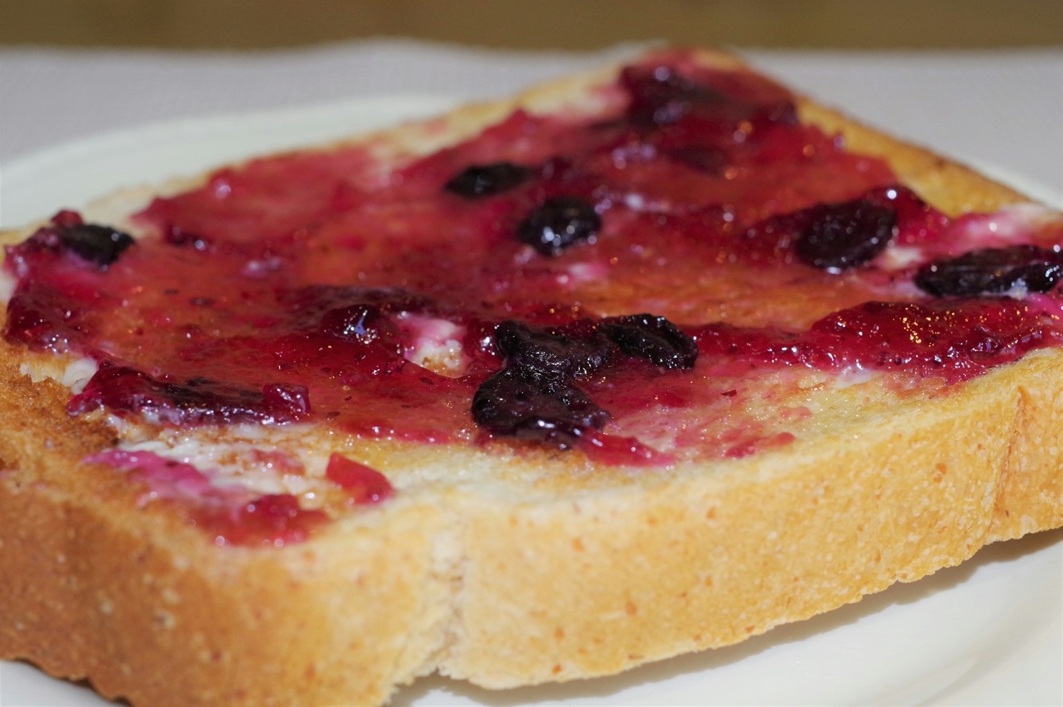 Tranche de pain grillé avec de la confiture sur une assiette blanche