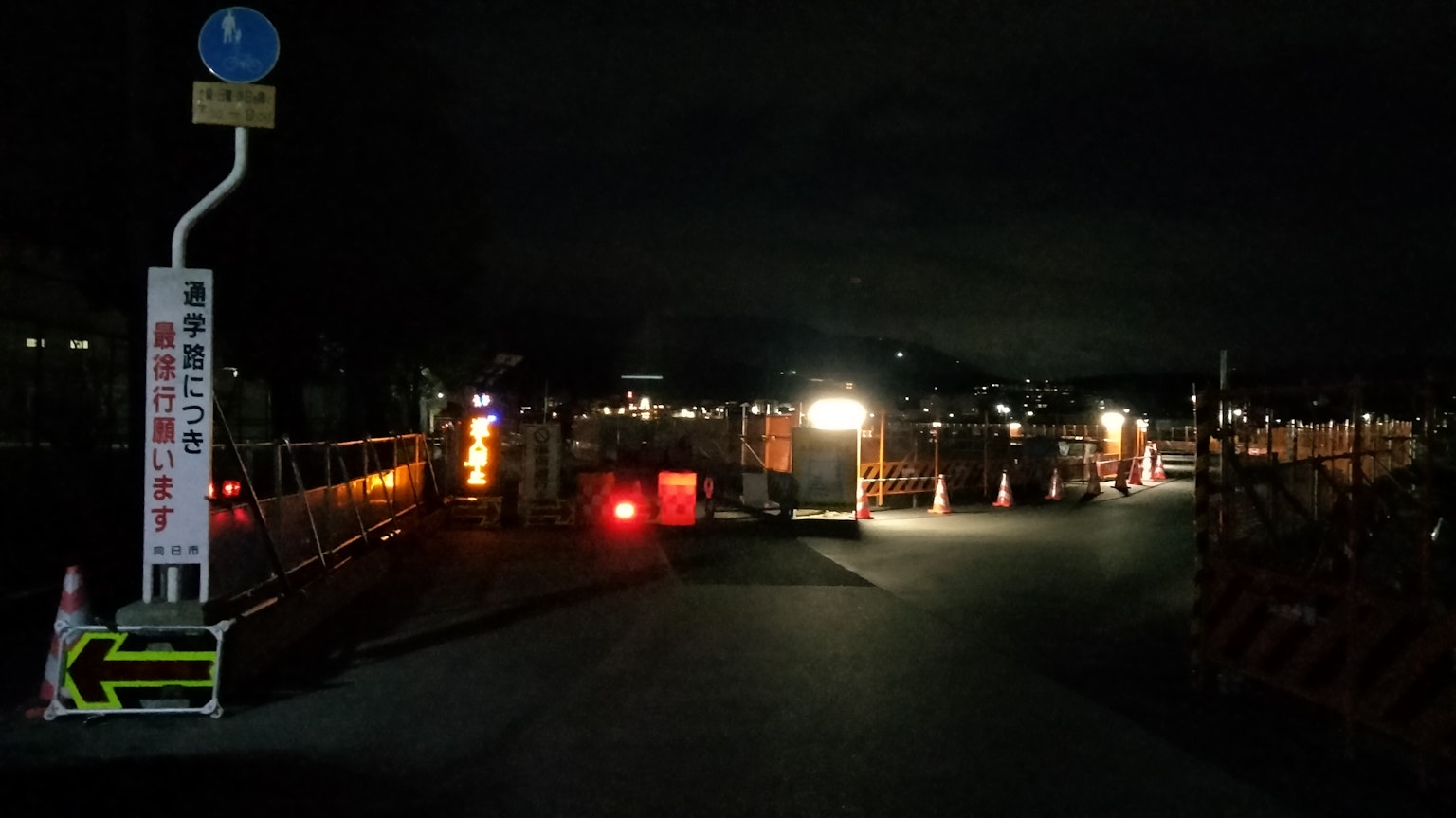 夜間施工現場，工作燈亮著，交通標誌可見