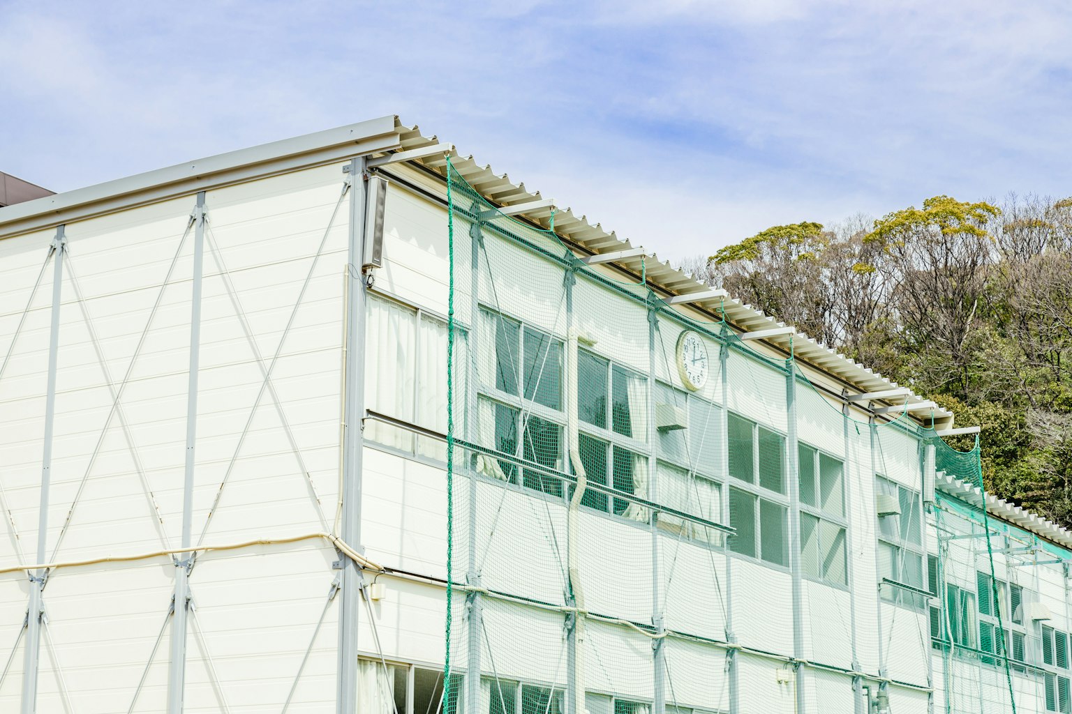 Site de construction avec un bâtiment doté d'un échafaudage vert et de grandes fenêtres