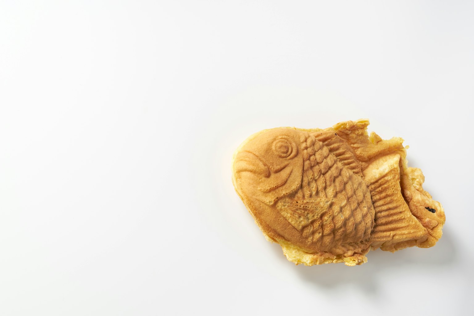 Une pâtisserie en forme de poisson sur un fond blanc