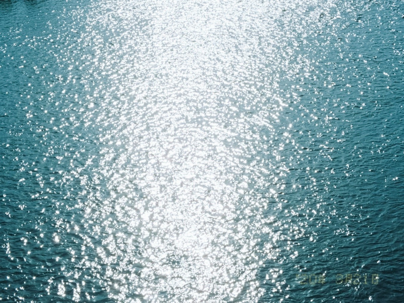 permukaan laut berkilau dengan riak terkena sinar matahari