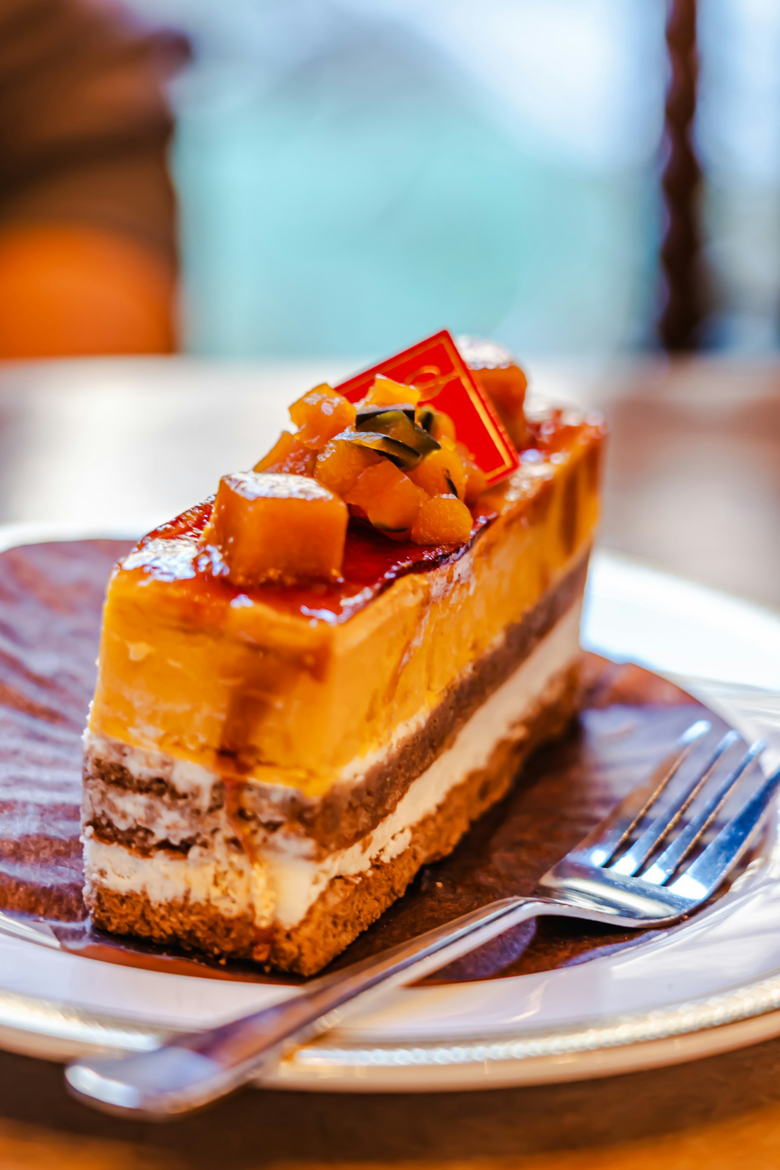 A slice of delicious cake topped with colorful fruit and a glossy glaze