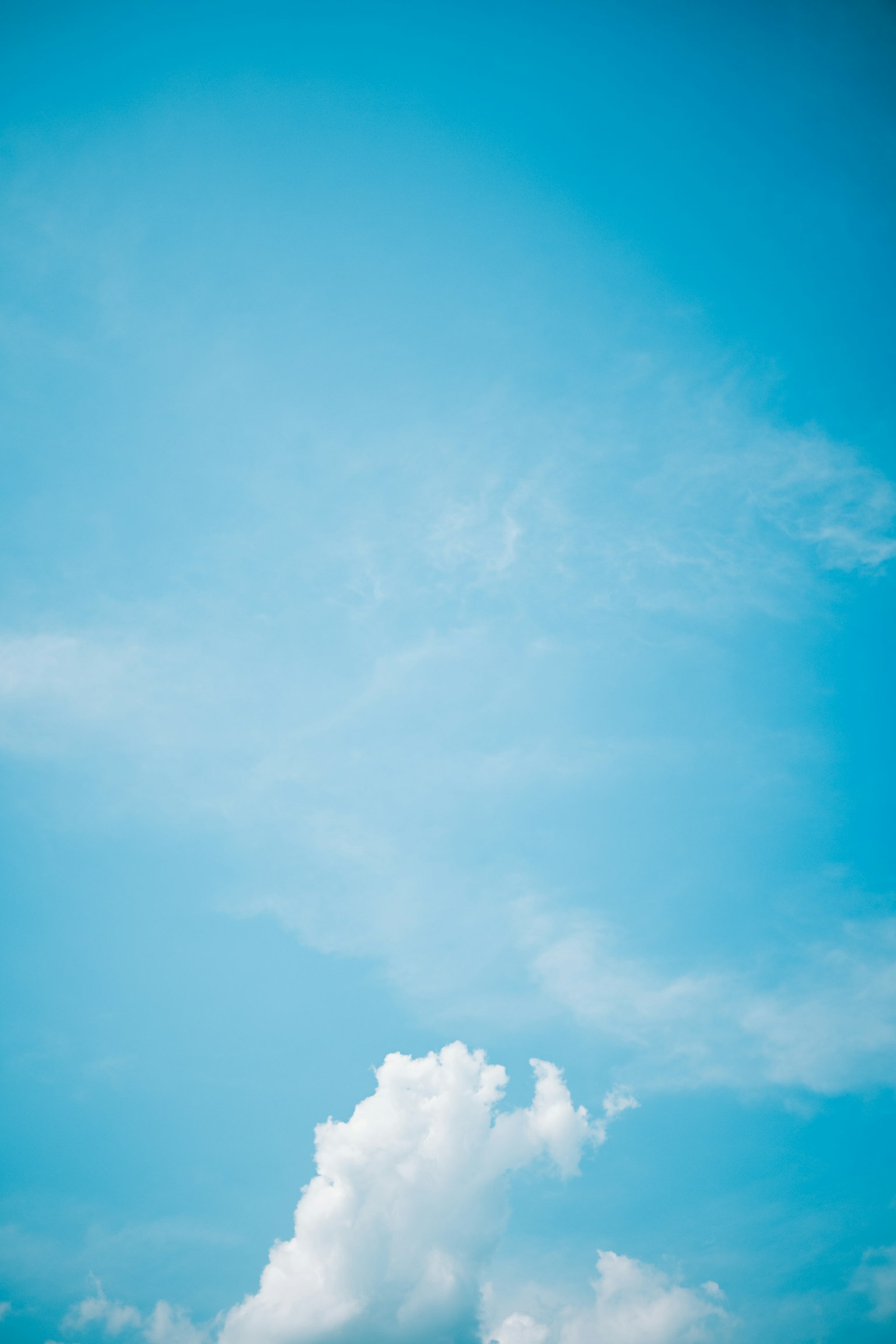 Ein klarer blauer Himmel mit flauschigen weißen Wolken