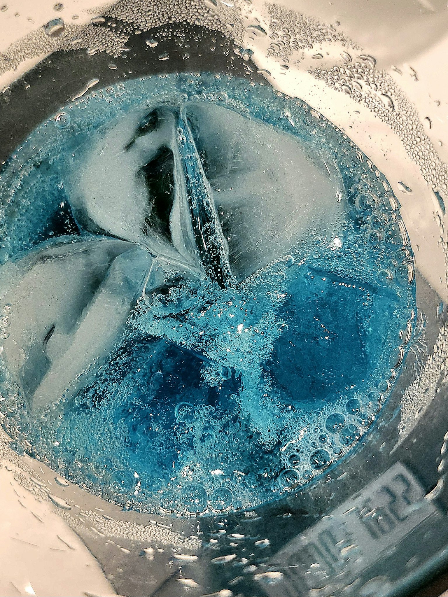 Top view of a transparent container with ice and blue liquid