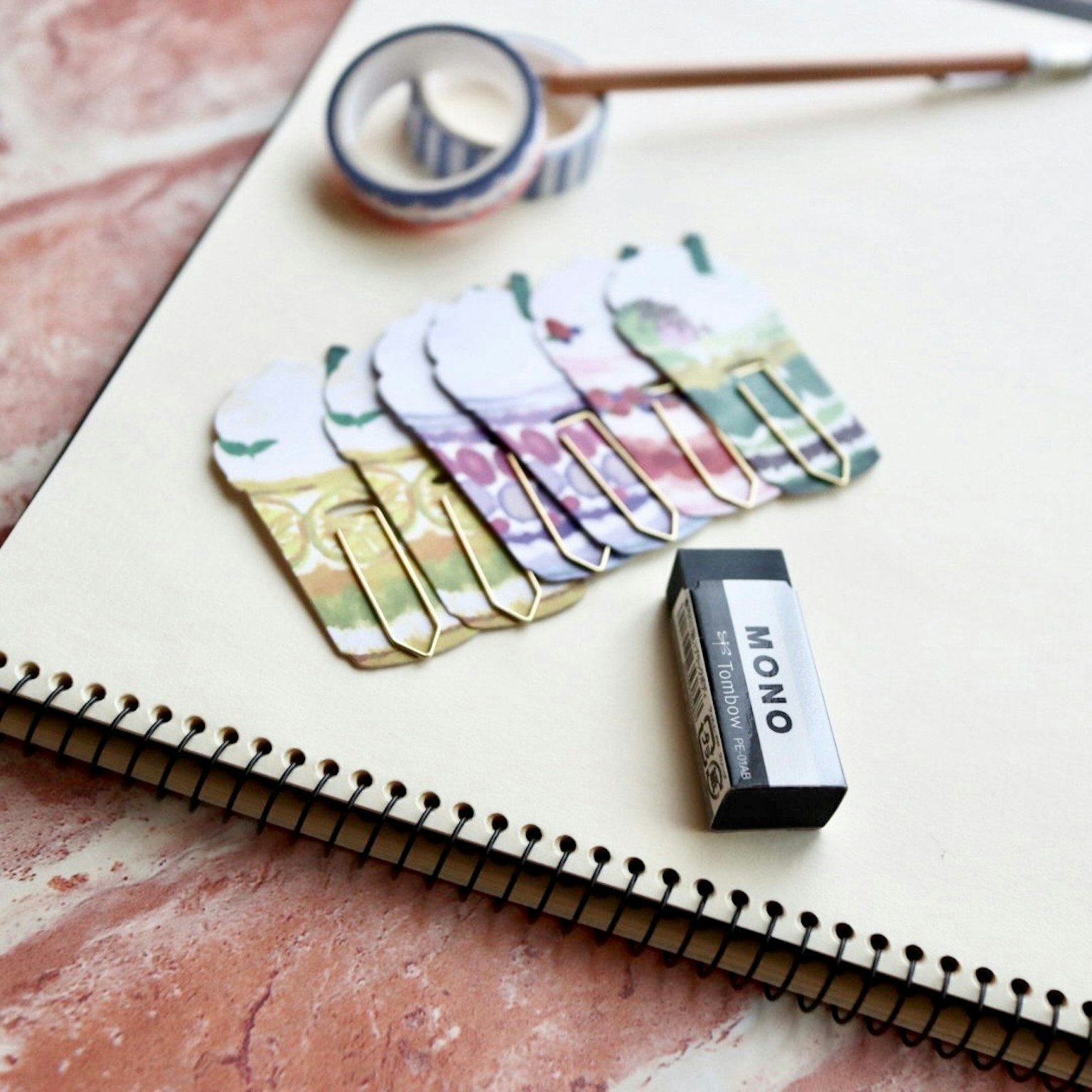 Clip de colores y una goma en un cuaderno de bocetos