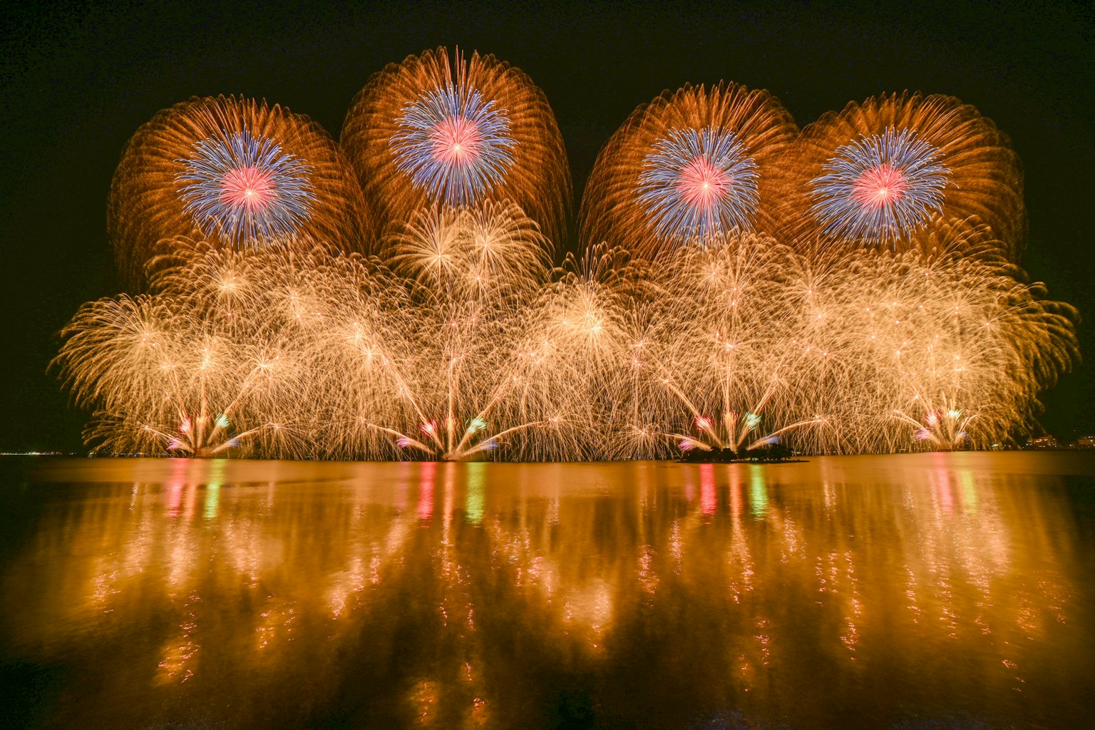 夜空中繽紛的煙火在水面上反射