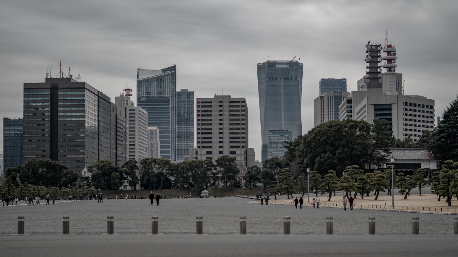 Cityscape featuring tall buildings under a cloudy sky with a spacious square