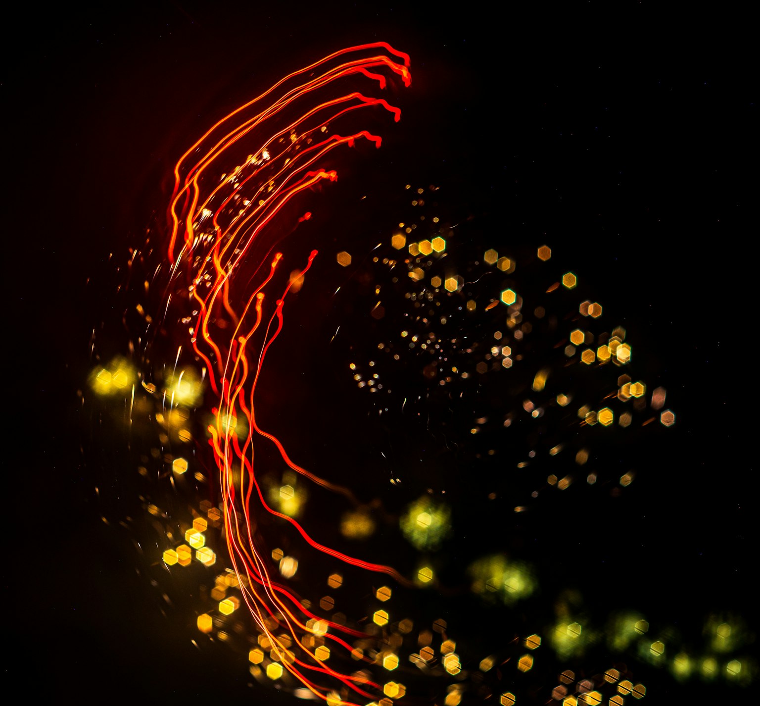 Abstraktes Bild mit roten und gelben Lichtspuren auf schwarzem Hintergrund