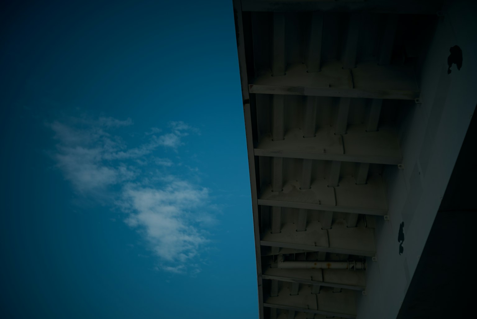 Parte di un edificio con cielo blu e nuvola bianca