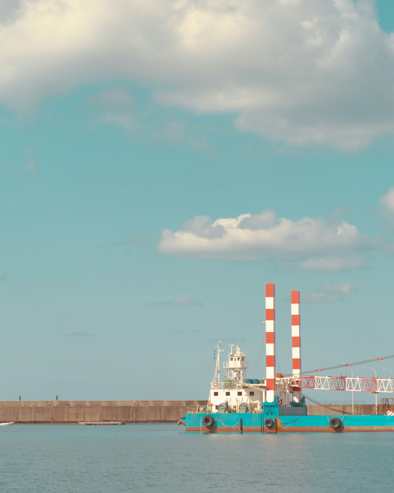 Bateau bleu avec des cheminées rouges et blanches près du port