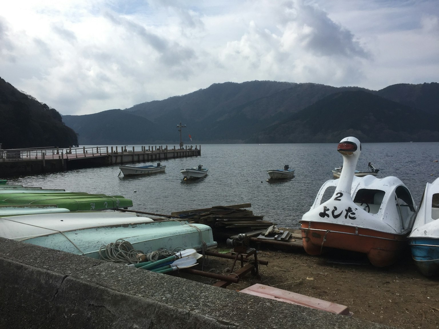 Boats by the lakeside with mountains in the background