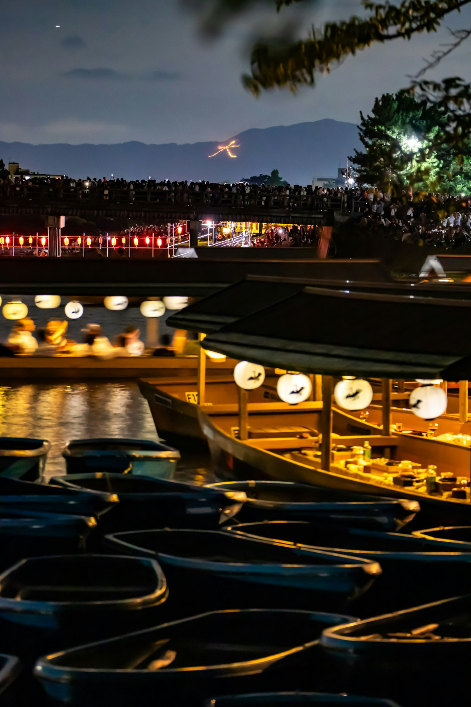 Bateaux sur un lac la nuit illuminés par des lanternes