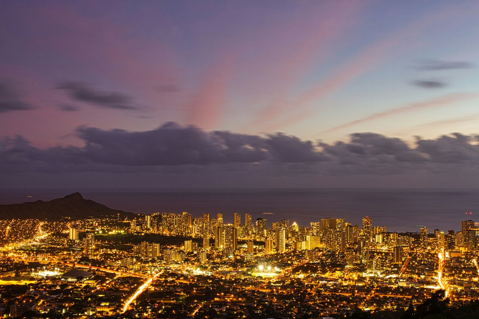 Twilight view of Honolulu with illuminated city skyline and ocean