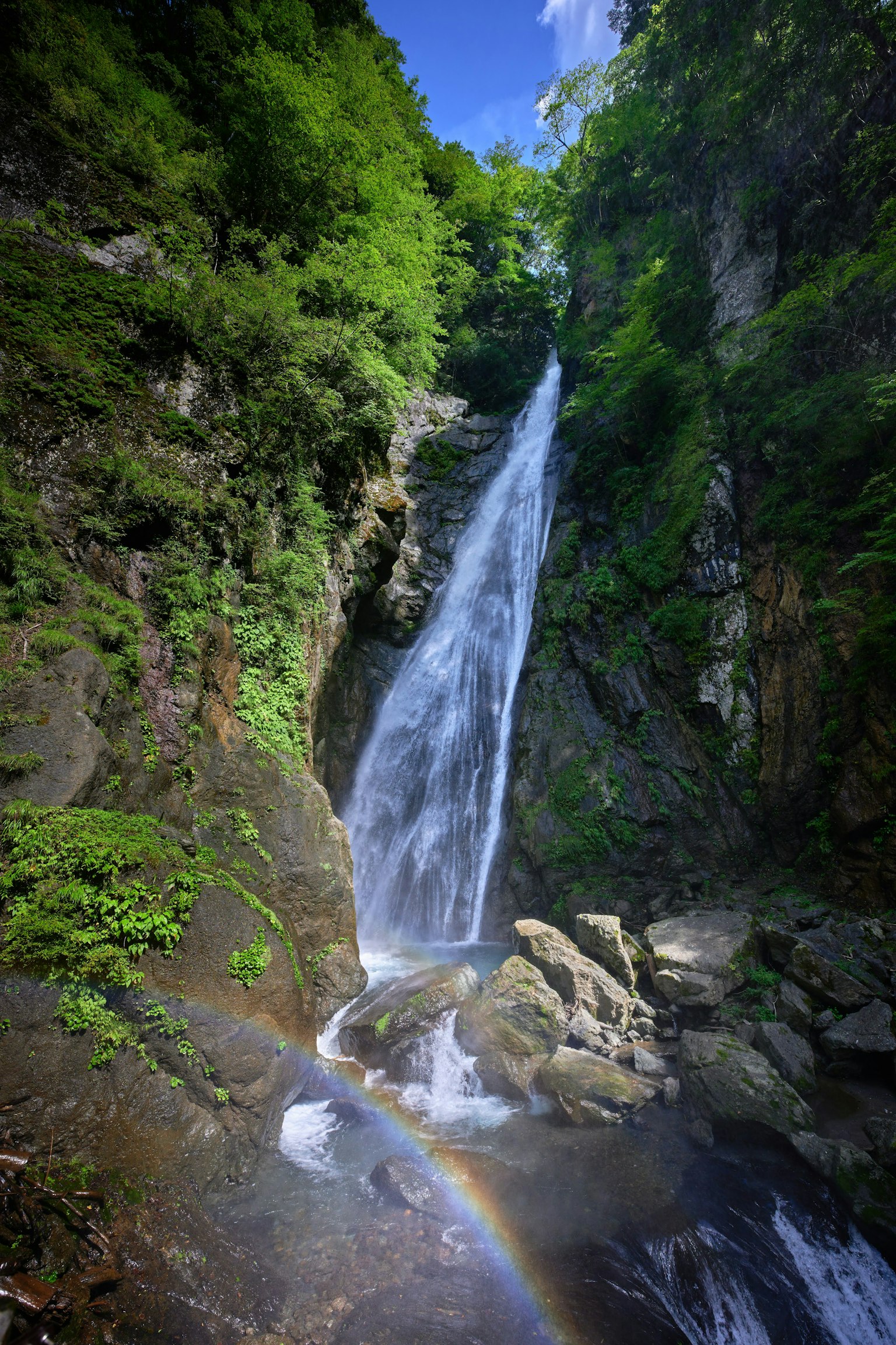 Una hermosa cascada que cae a través de montañas verdes