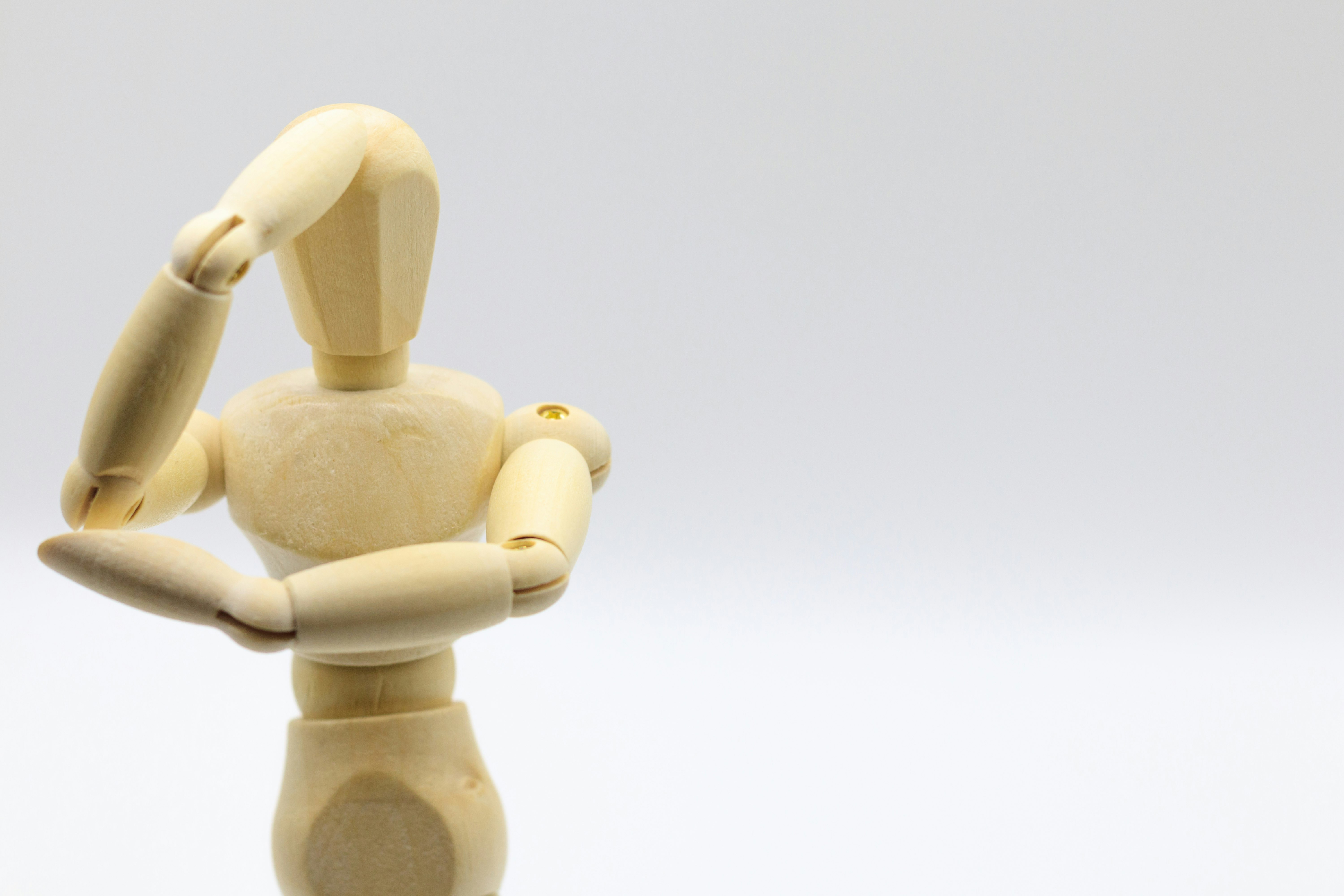 白背景の木製マネキン風フィギュアのポーズ