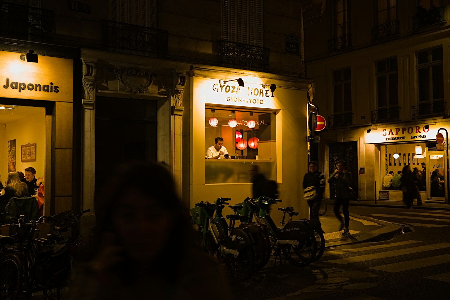 Eksterior restoran Jepang di jalan Paris di malam hari dengan lampu terang