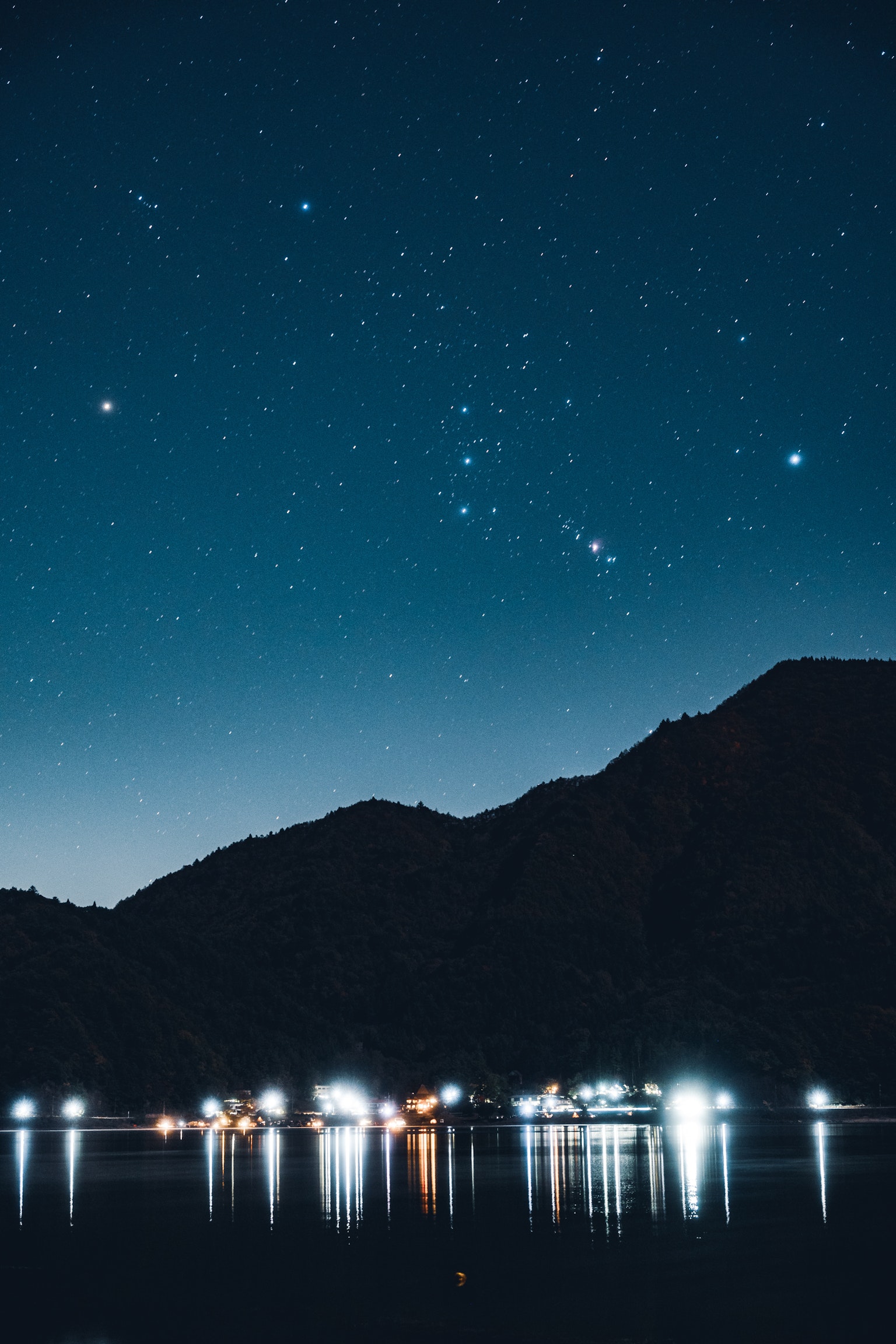星空と山々が映る静かな湖の風景