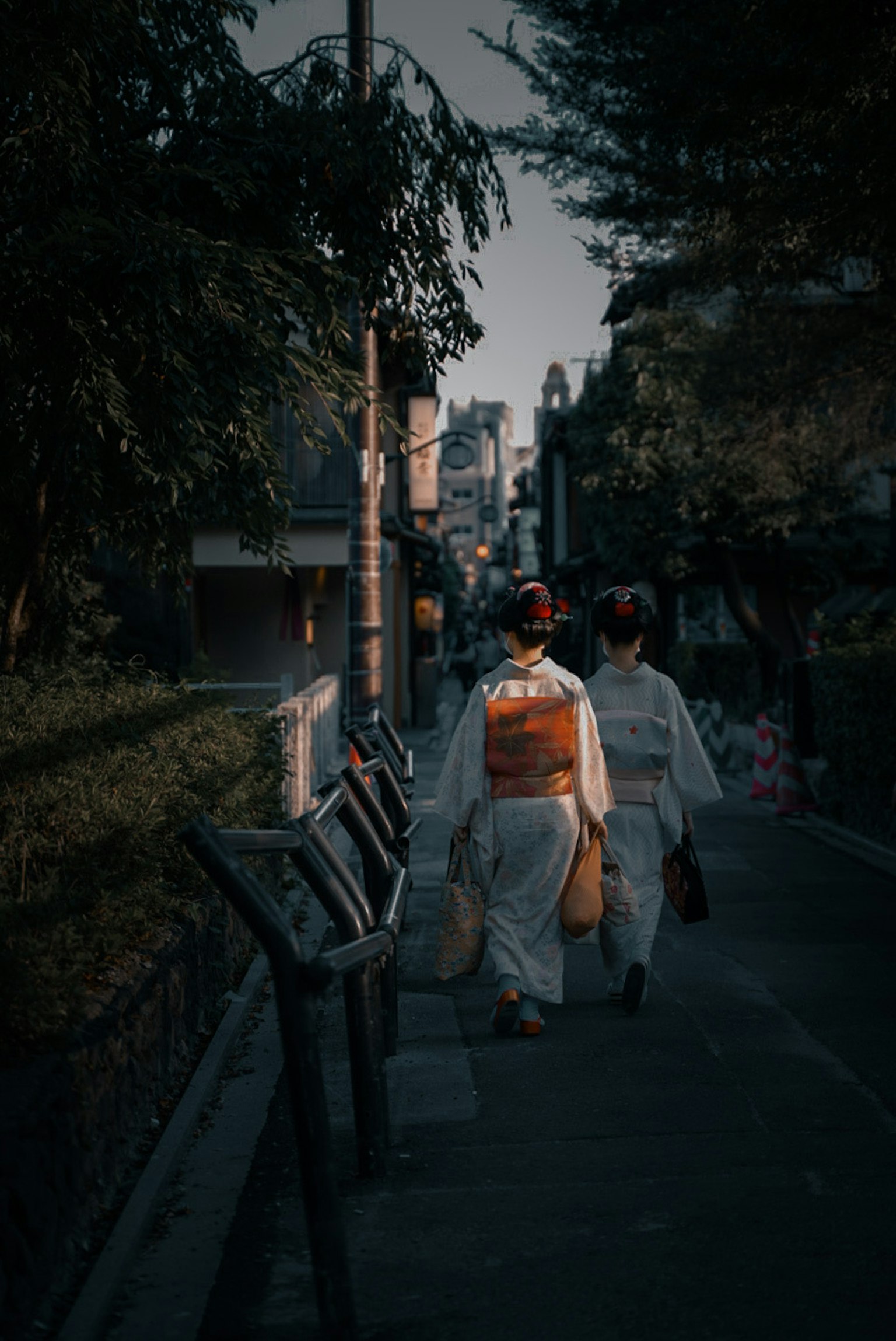 Two women walking in traditional kimonos along a street