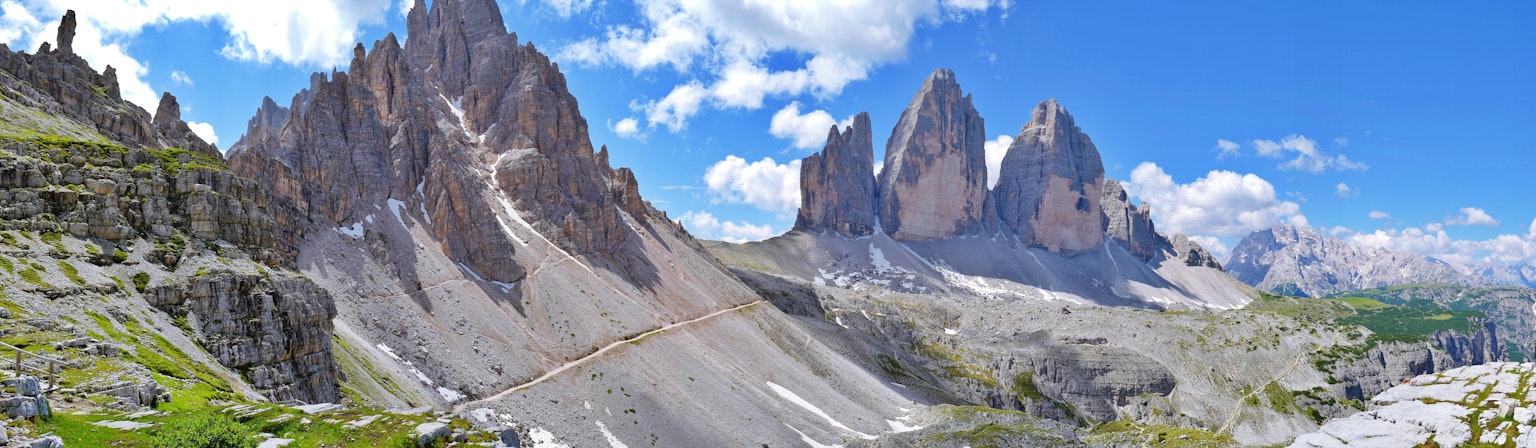 Panoramablick auf die schönen Dolomiten mit grünen Wiesen und blauem Himmel