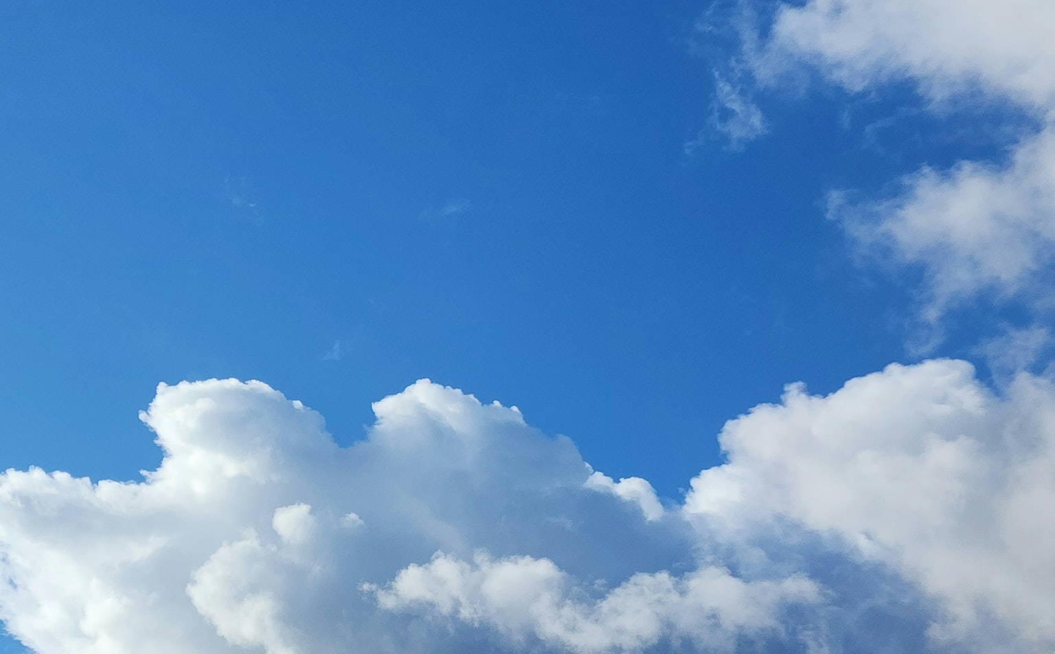 View of blue sky with fluffy white clouds