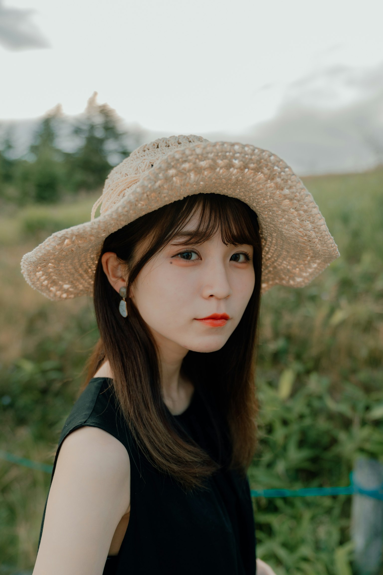 草地上戴着草帽的女性肖像