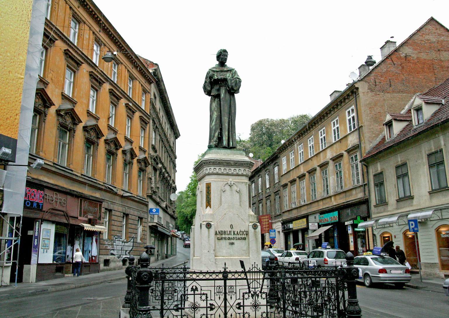 Statue in the center of a street with historic buildings