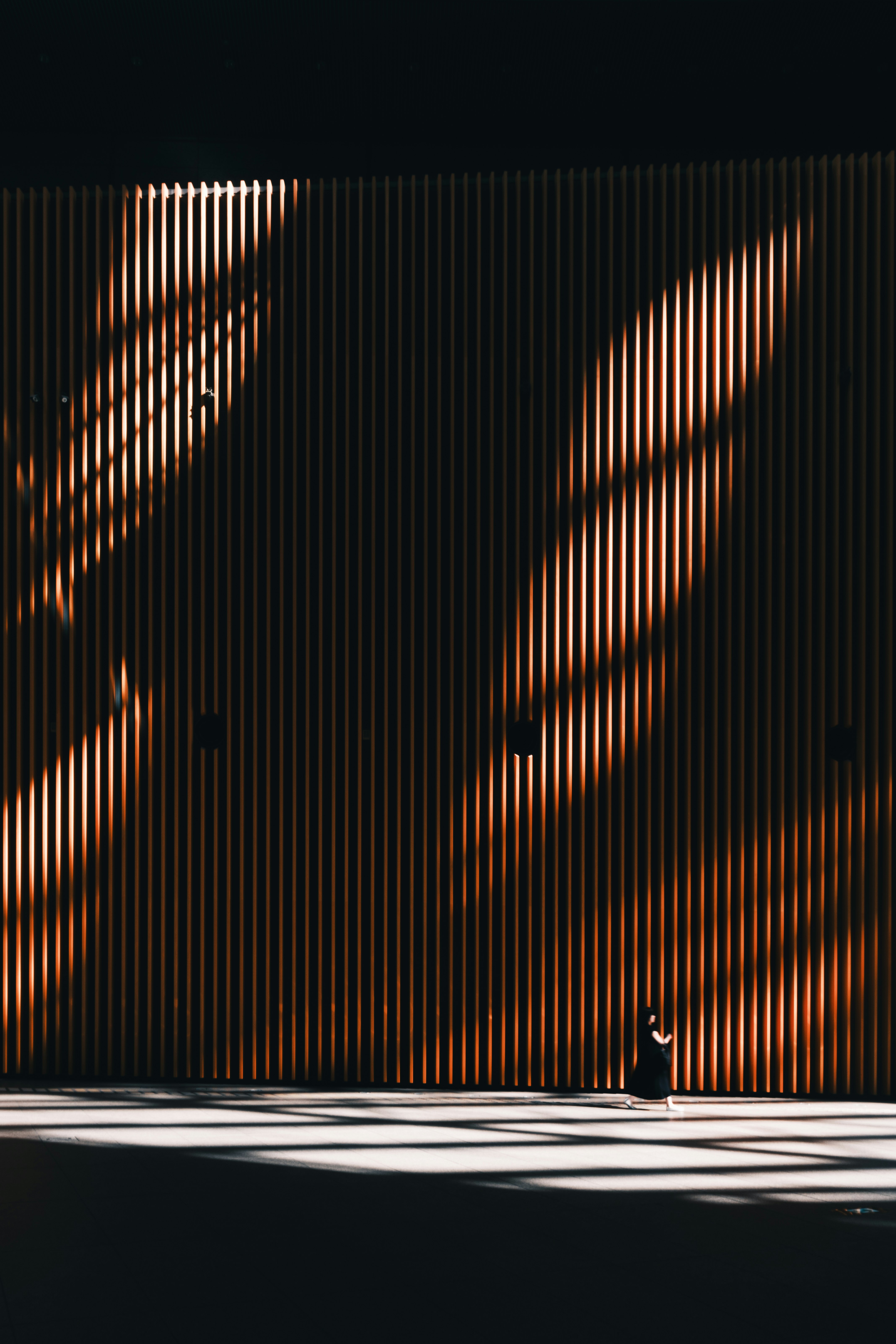Geometric light and shadow pattern on a slatted wall