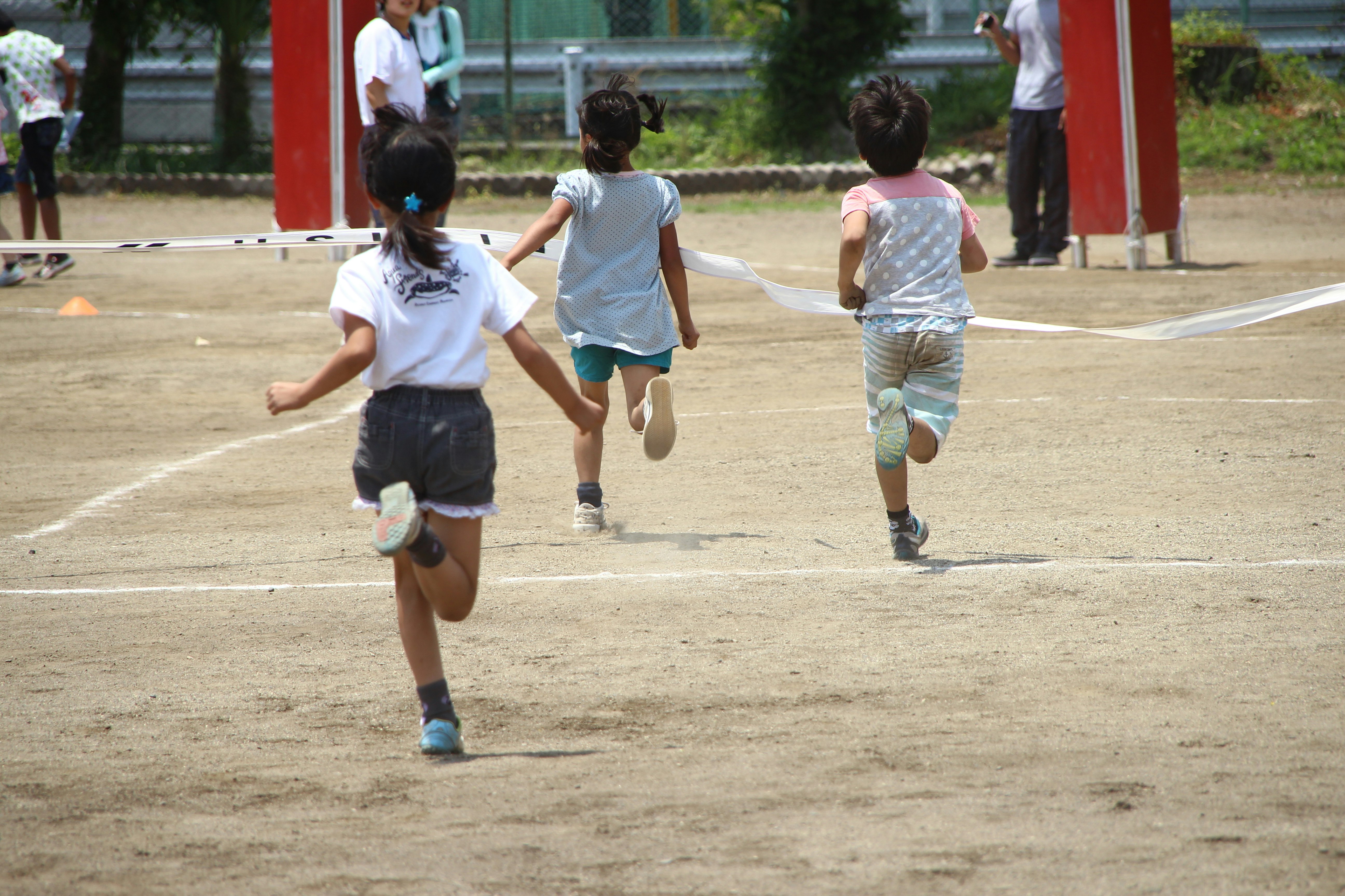 校庭で徒競走をする子どもたちの後ろ姿
